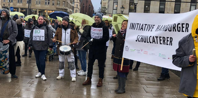 Menschen mit Trommeln stehen im Regen