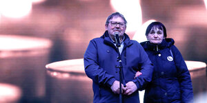 Die Eltern von Jan Kuciak vor einem Mikrofon. Im Hintergrund verschwommene Projektion auf einer Leinwand