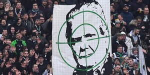 Graldbacher Fans in der Kurve zeigen ein Transparent mit Hoffenheims Mäzen Dietmar Hopp im Fadenkreuz