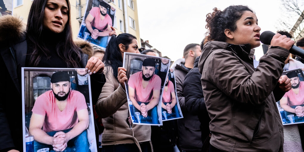 Menschen auf einer Kundgebung, die Fotos hochhalten