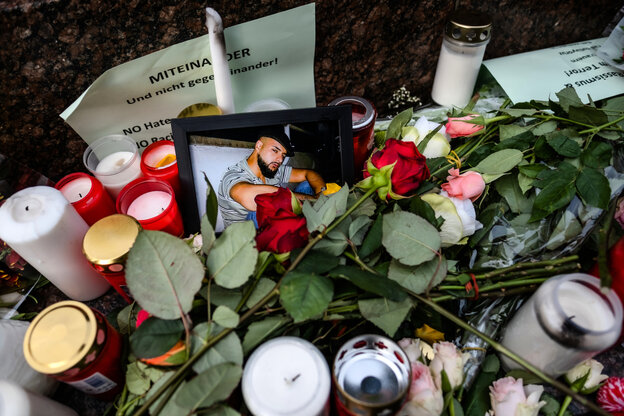 Bild eines Opfers der rassistischen Morde in Hanau zwischen Blumen. Bild eines Opfers der rassistischen Morde in Hanau zwischen Blumen.