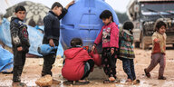 Mehrere Kinder holen Wasser aus einem Tank