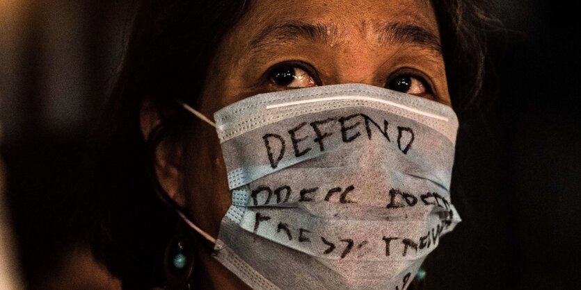 Eine Demonstrantin trägt einen Mundschutz in Quezon City