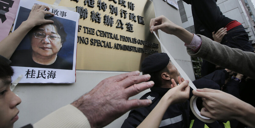 Ein Foto wird vor chinesischen Schriftzeichen aufgehängt