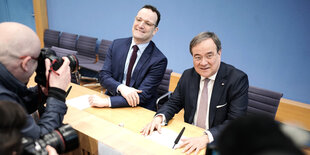 Jens Spahn (l), Gesundheitsminister, und Armin Laschet (beide CDU), Ministerpräsident von Nordrhein-Westfalen, umringt von Fotografen bei einer Pressekonferenz..