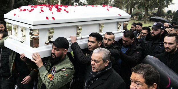Männer tragen einen weißen Sarg bei einer Beerdigung nach den rassistischen Morden in
