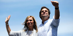 Der designierte Präsident und die Vizepräsidentin winken im Sonnenlicht vor blauem Himmel