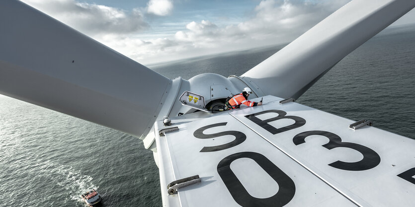 Ein Bauarbeiter werkelt in luftiger Höhe an einem Hochseewindpark