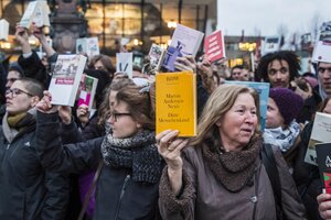 Menschen halten Bücher in die Höhe.