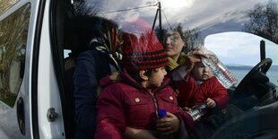 Eine Familie sitzt mit Wasserflaschen in einem Auto