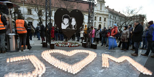 Menschen gedenken auf einem Platz Jan Kuciak und seiner Freundin. Viele Kerzen sind auf dem Boden zu einem J, einem Herzen und einem M formiert worden