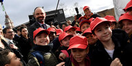 eine Gruppe von Kindern, die rote Basecaps tragen