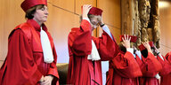 stehende RichterInnen in roten Roben