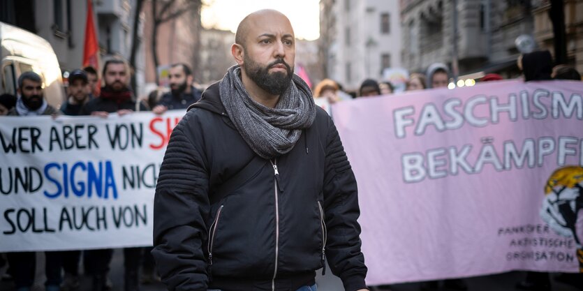 Eine Demo gegen rechten Terror in Berlin-Neukölln: der Linken-Politiker Ferat Kocak steht vor einem riesigen Banner mit dem Schriftzug "Faschismus bekämpfen"