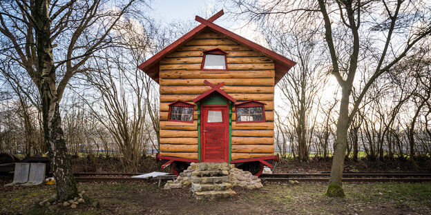 Zwei kleine Holzhäuser stehen auf einer Wiese