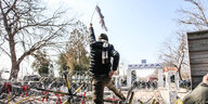 Ein Mann wedelt mit einer weißen Fahne am Stacheldraht an der türkisch-griechischen Grenze.