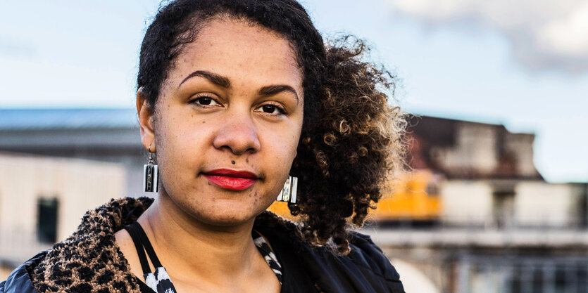 Portrait von Olivia Wenzel in einer Stadtlandschaft.