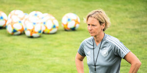 Martina Voss-Tecklenburg, Trainerin der deutschen Frauenfußball-Nationalmannschaft, steht auf einem Trainingsplatz.