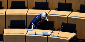 Eine Reinigungskraft wischt die Tische im Thüringer Landtag ab.