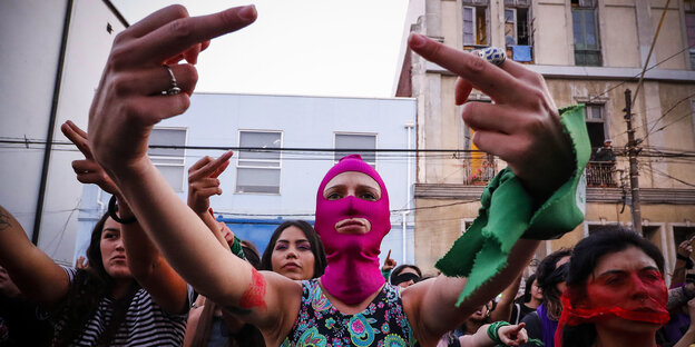Chile, Valparaíso: Eine vermummte Frau zeigt den dritten Finger am Rande einer Performance der feministischen Gruppe «Las Tesis» in Chile. Die Performance der feministischen Gruppe geht um die Welt.