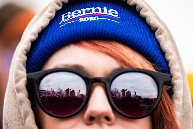 Eine Frau trägt eine Sonnenbrille in deren Gläsern sich der demokratische Präsidentschaftskandidat Bernie Sanders spiegelt