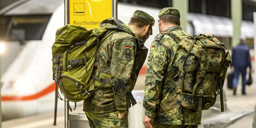 Soldaten auf einem Bahnsteig.