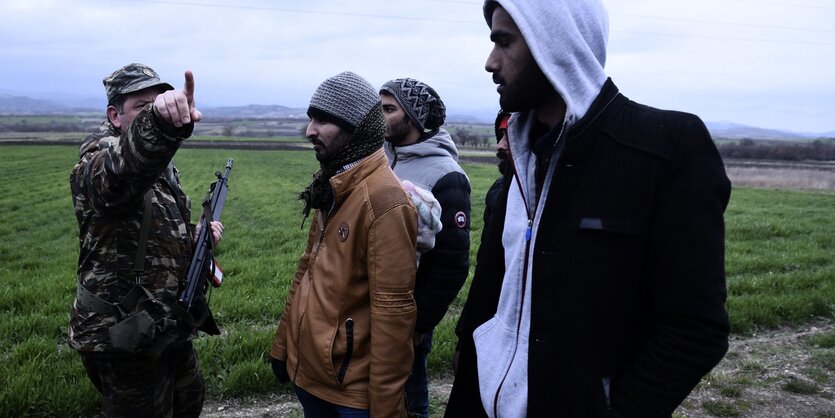 Ein griechischer Soldat verhaftet Flüchtlinge an der Grenze zur Türkei.