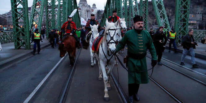 Mitglieder einer nationalistischen Gruppe marschieren auf einer Brücke in Ugarn