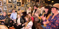 Menschen musizieren und klatschen in einem Pub