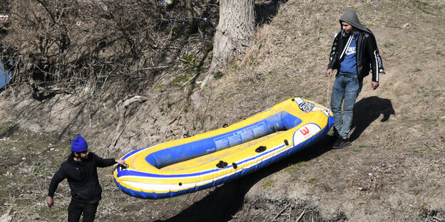 Zwei Flüchtlinge mit einem Schlauchboot auf dem Weg zum Grenzfluss Evros.