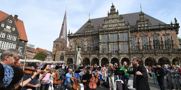Menschen mit Musikinstrumenten vor dem Bremer Rathaus