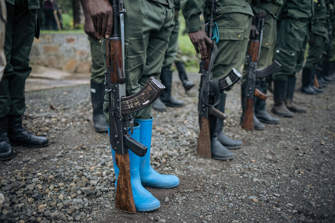 Blick auf Stiefel von Soldaten, die mit Gewehr hab acht stehen