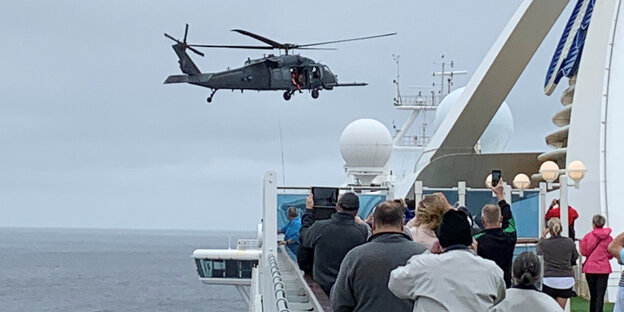 Passagiere auf dem Kreuzfahrtschiff Grand Princess bobachten einen Militärhubschrauber. Passagiere auf dem Kreuzfahrtschiff Grand Princess bobachten einen Militärhubschrauber.