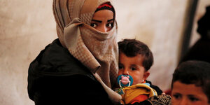 Eine Frau mit ihren Kindern in einem Flüchtlingslager bei Idlib.