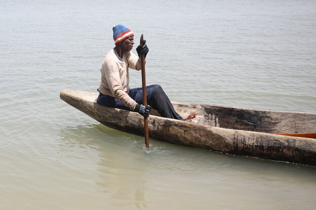 Frau mit Mütze in einem geschnitzten Boot