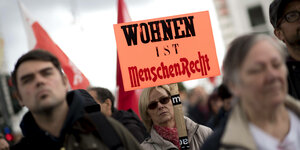 Mietendemo in Berlin: Eine Frau demonstriert mit einem Schild, auf dem "Wohnen ist Menschenrecht" steht.