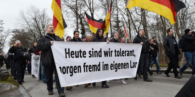 Demonstranten tragen Deutschland-Fahnen und ein Transparent mit der Aufschrift «Heute sind wir tolerant, morgen fremd im eigenen Land»