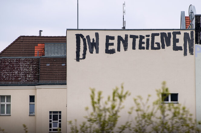 Auf einer Hauswand steht ein Slogan für Enteignung