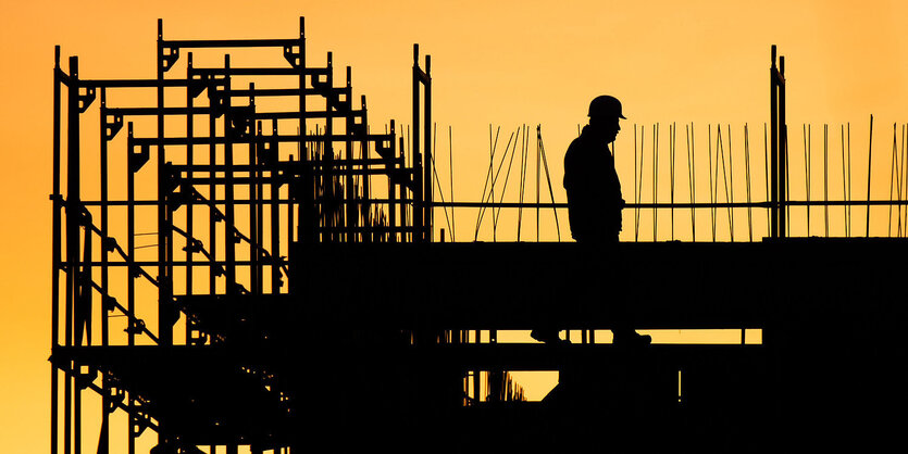 Silhouette einer Baustelle, auf der ein Bauarbeiter zu sehen ist