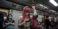 Menschen mit Atemschutzmasken in der Hongkonger U-Bahn