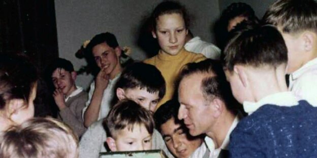 Buntes Bild: Mann in der Mitte, umgeben von Kindern