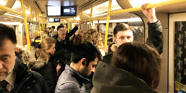 Menschen in einem ueberfuellten Zugabteil der U-Bahn in Berlin