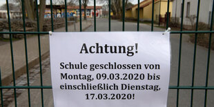 Ein Schild hängt vor dem eingang einer Schule