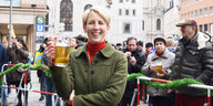 Katrin Habenschaden mit einem Bierkrug auf dem Marienplatz in München.