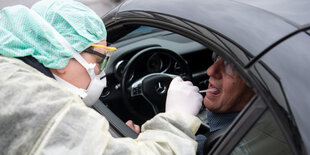 Eine Mitarbeiterin eines Krankenhauses nimmt während eines Pressetermins zum Start einer "Drive-In"-Teststation für den Coronavirus in Nürtingen.