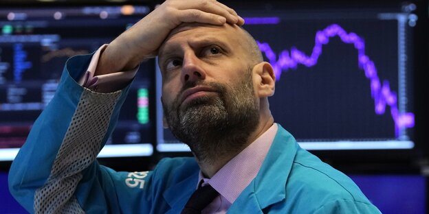 Ein Wertpapierhändler an der Wall Street fasst sich fassungslos an den Kopf.
