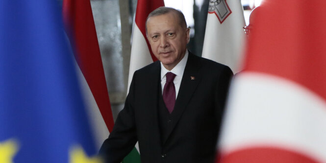 Präsident Recep Tayyip Erdoğan in Brüssel zwischen einer Flagge der EU (links) und einer Flagge der Türkei (rechtes)