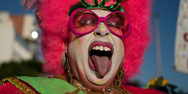 Mann im Karneval streckt Zunge raus