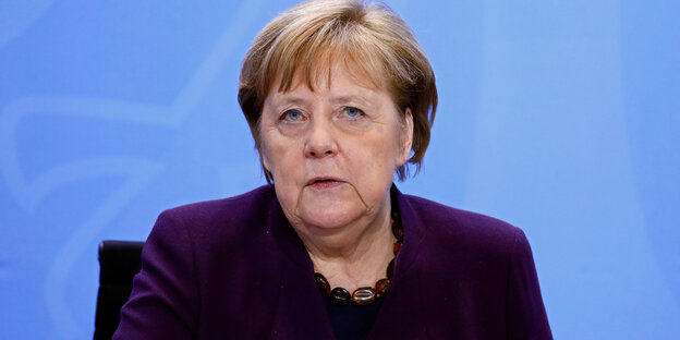Merkel auf der Pressekonferenz vor blauer Wand