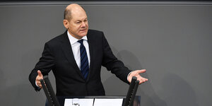 Olaf Scholz steht im Bundestag an einem Rednerpult und spricht